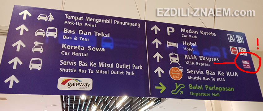 Фиолетовые указатели на поезда KLIA Transit в аэропорту Куала Лумпур